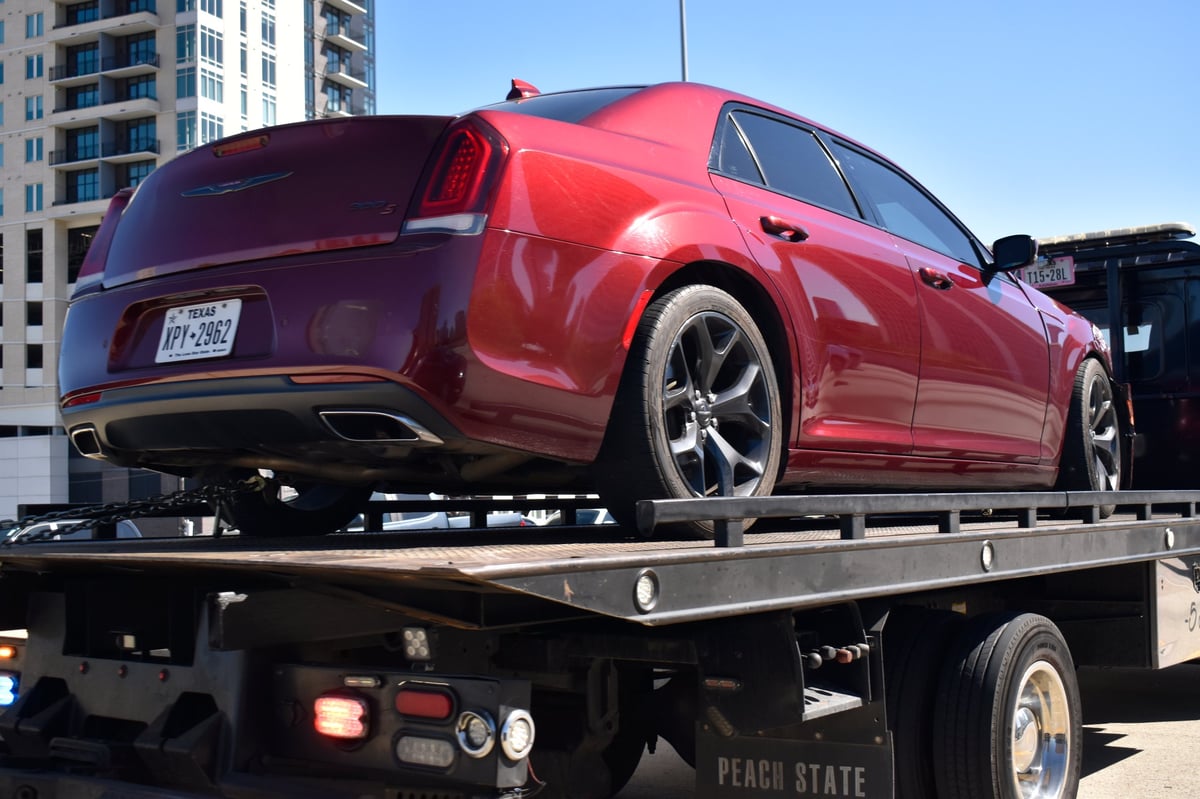 Wrecked car on a flatbed tow truck being transported